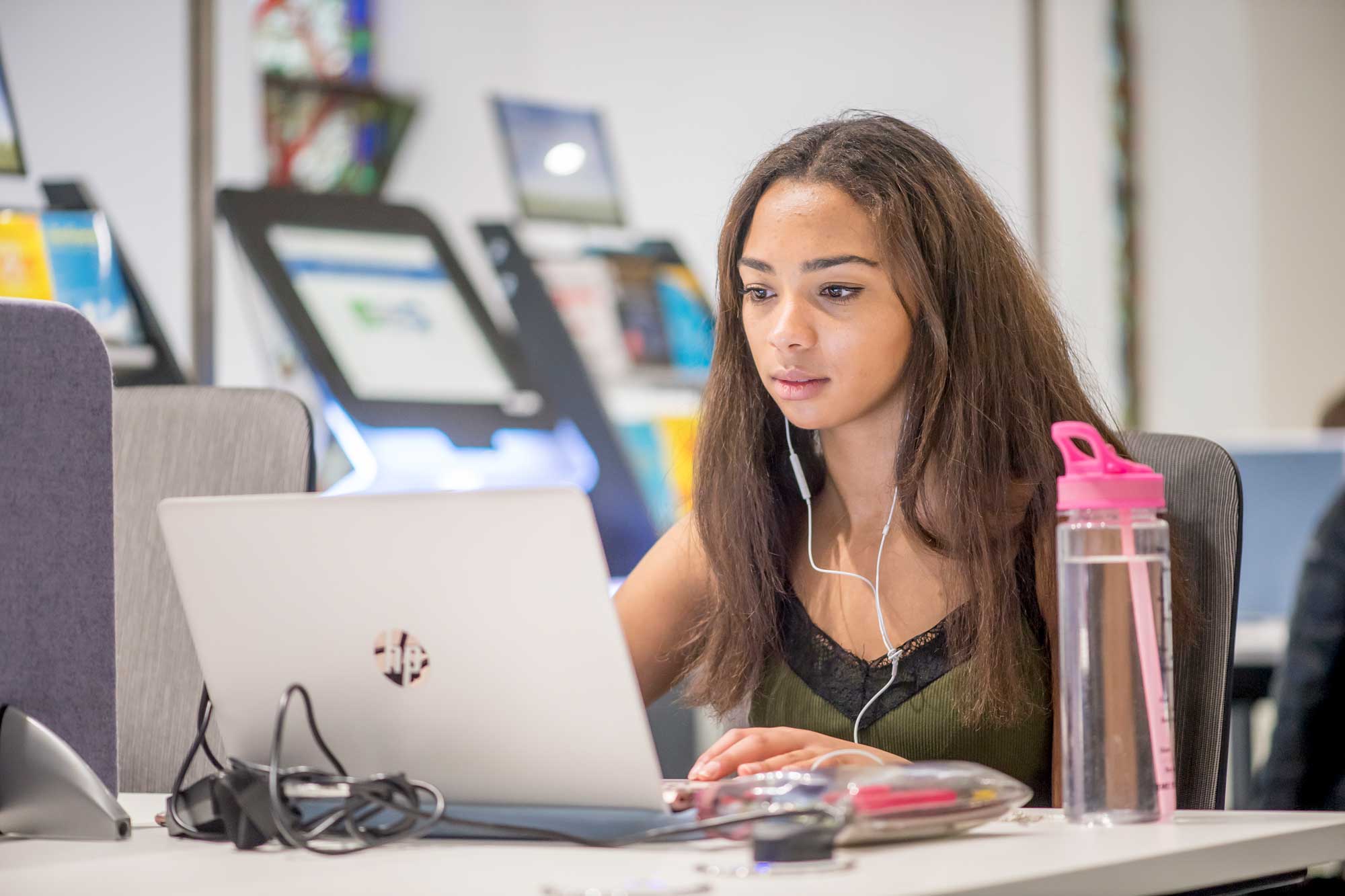 Student in AECC Library using a laptop