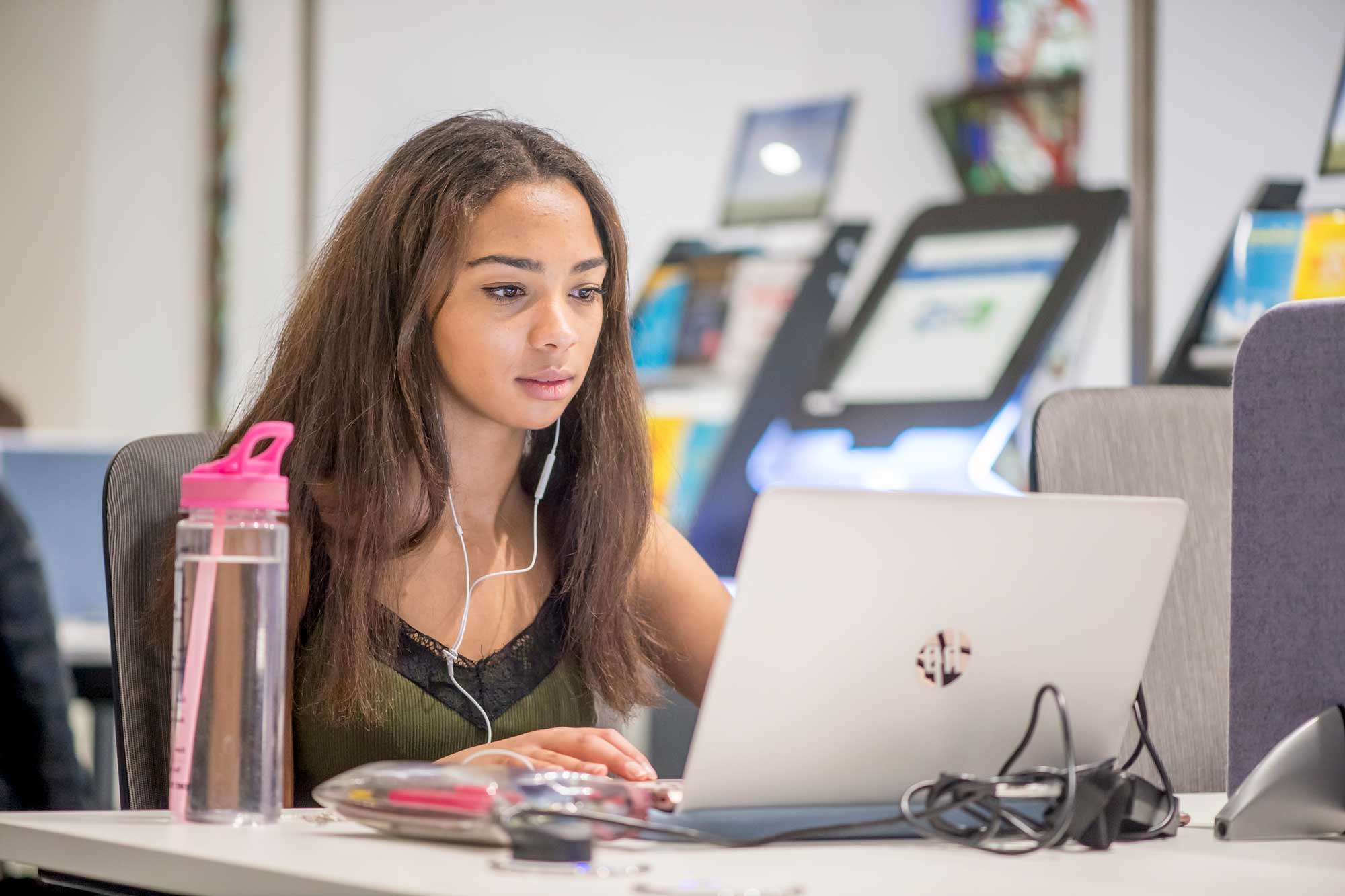 Student in AECC Library using a laptop