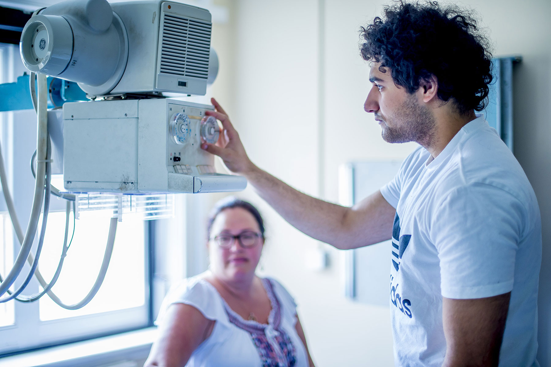 Male student using an imaging machine on a patient