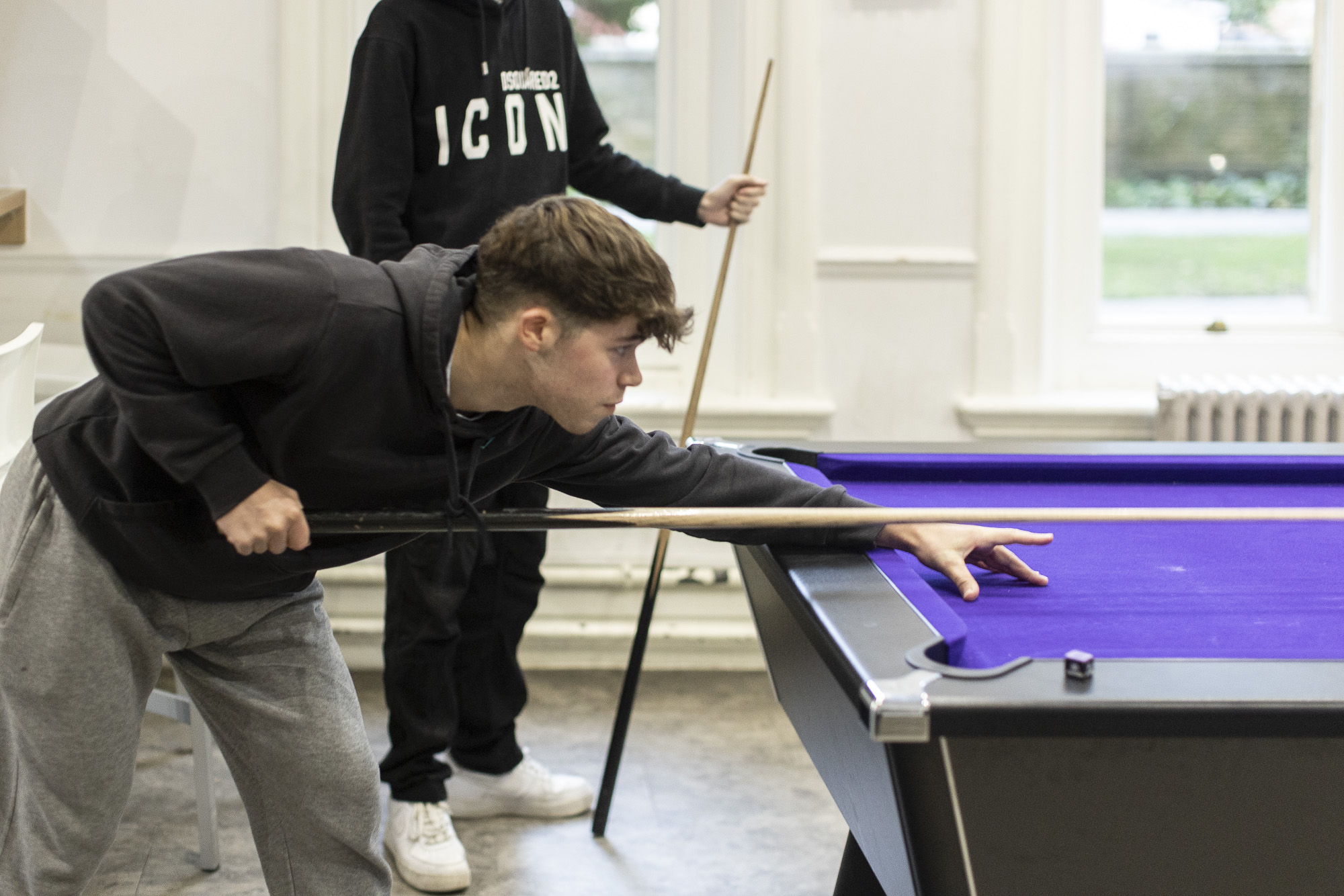 Two students playing pool