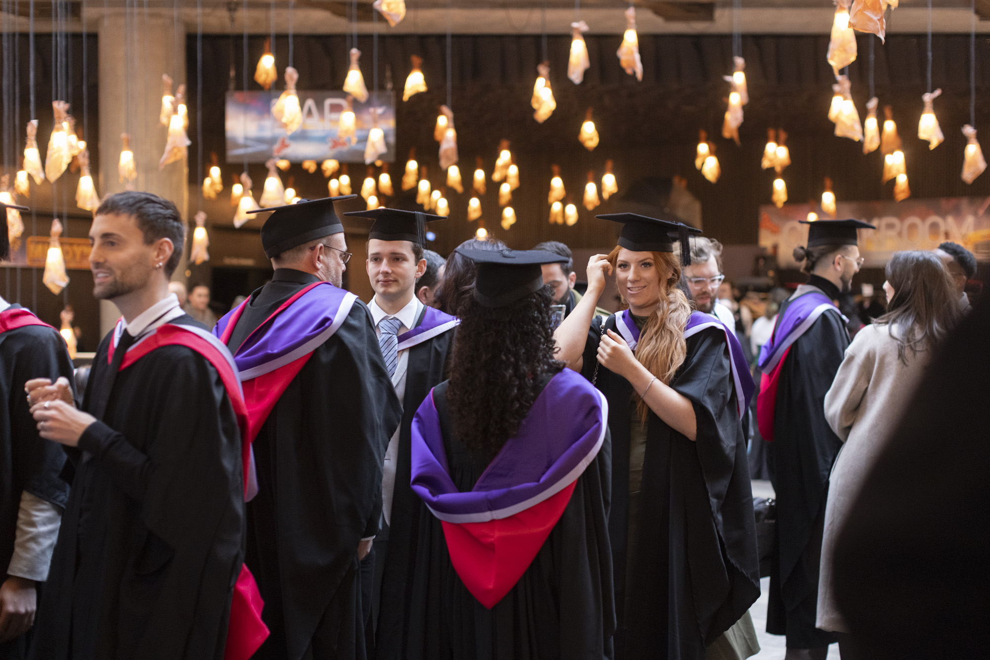 Graduates gather in their robes for the ceremony at Bridge Theatre.